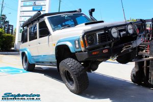 Right front view of a Blue Nissan GQ Patrol flexing its front left wheel after fitment of a Superior Remote Reservoir Hybrid Superflex 3" Inch Lift Kit