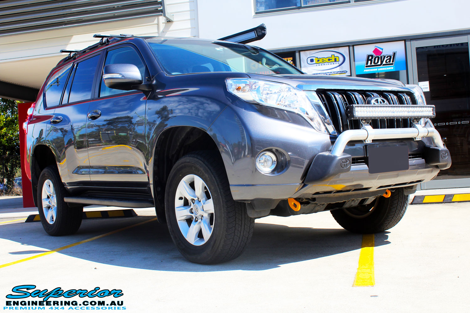 Right front side view of a Grey Toyota 150 Landcruiser Prado Wagon after fitment of a Superior Remote Reservoir 2" Inch Lift Kit, Airbag Man Coil Air Kit & King Springs