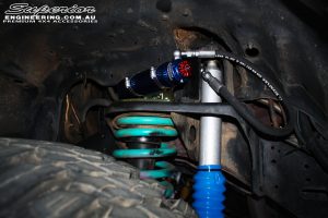 Inner right side guard view of the fitted Superior 3" Remote Reservoir shock with Coil Spring