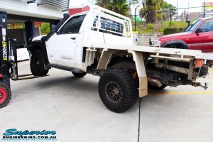 Left rear side view of a White Nissan GU Patrol Ute showing its rear flex after fitting the Superior 4" Inch Remote Reservoir Hyperflex Kit