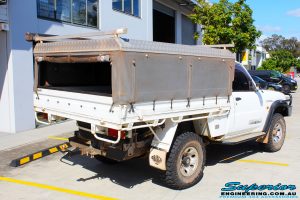 Rear right view of a Nissan GU Patrol Ute in Gold On The Hoist @ Superior Engineering Deception Bay Showroom