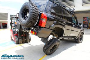 Rear right side view of a Black Nissan GU Patrol Wagon being flexed after fitting the Superior 2" Inch Remote Reservoir Hyperflex Kit with Front & Rear Superflex Sway Bar Kits, Comp Spec 4340m Tie Rod, Long Arms and Coil Tower Brace Kit