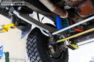 Front left underbody view of the fitted Superior Hyperflex Radius Arm with Tie Rod, Superflex Sway Bar Kit and Remote Reservoir Shock