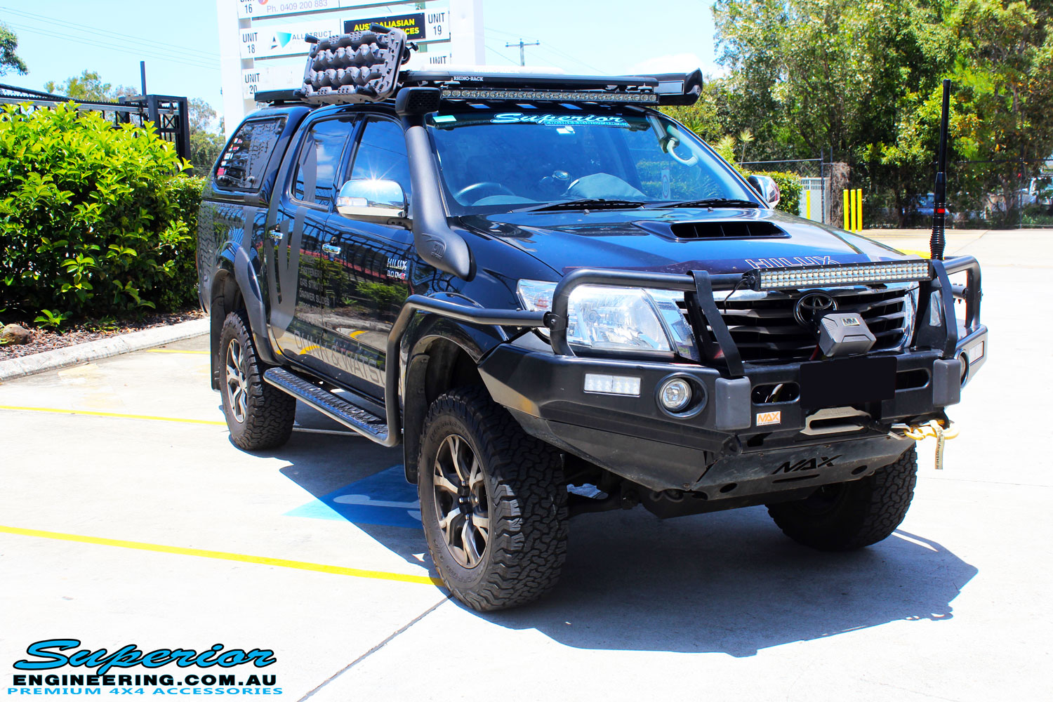 Right front side view of a Black Toyota Vigo Hilux after fitment of Superior Nitro Gas Front Struts, Coil Springs & GME Super Compact UHF CB with Antenna