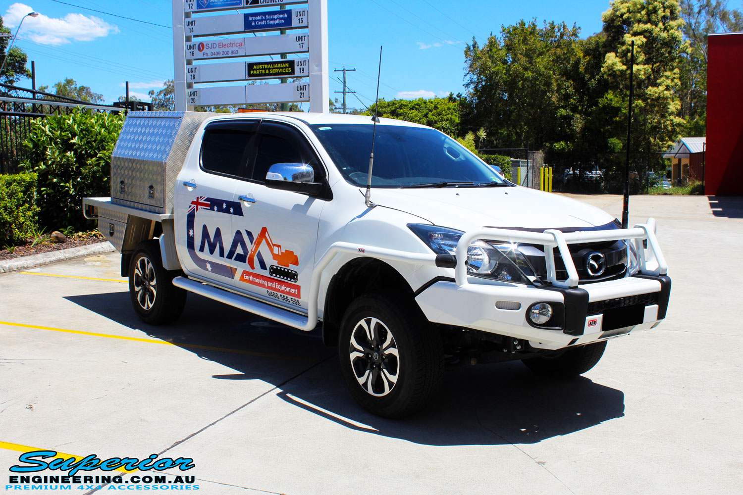 Right front side view of a White Mazda BT50 Dual Cab after fitment of a Superior 2" Inch Remote Reservoir Lift Kit