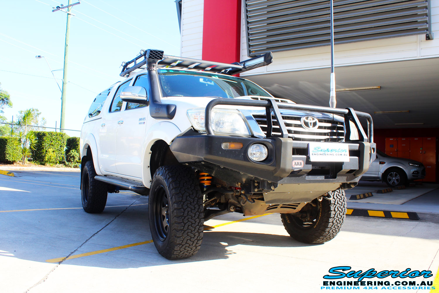 Right front side view of a Toyota Vigo Hilux Dual Cab in White after fitment of a Superior Remote Reservoir 4" Inch Lift Kit with King Springs