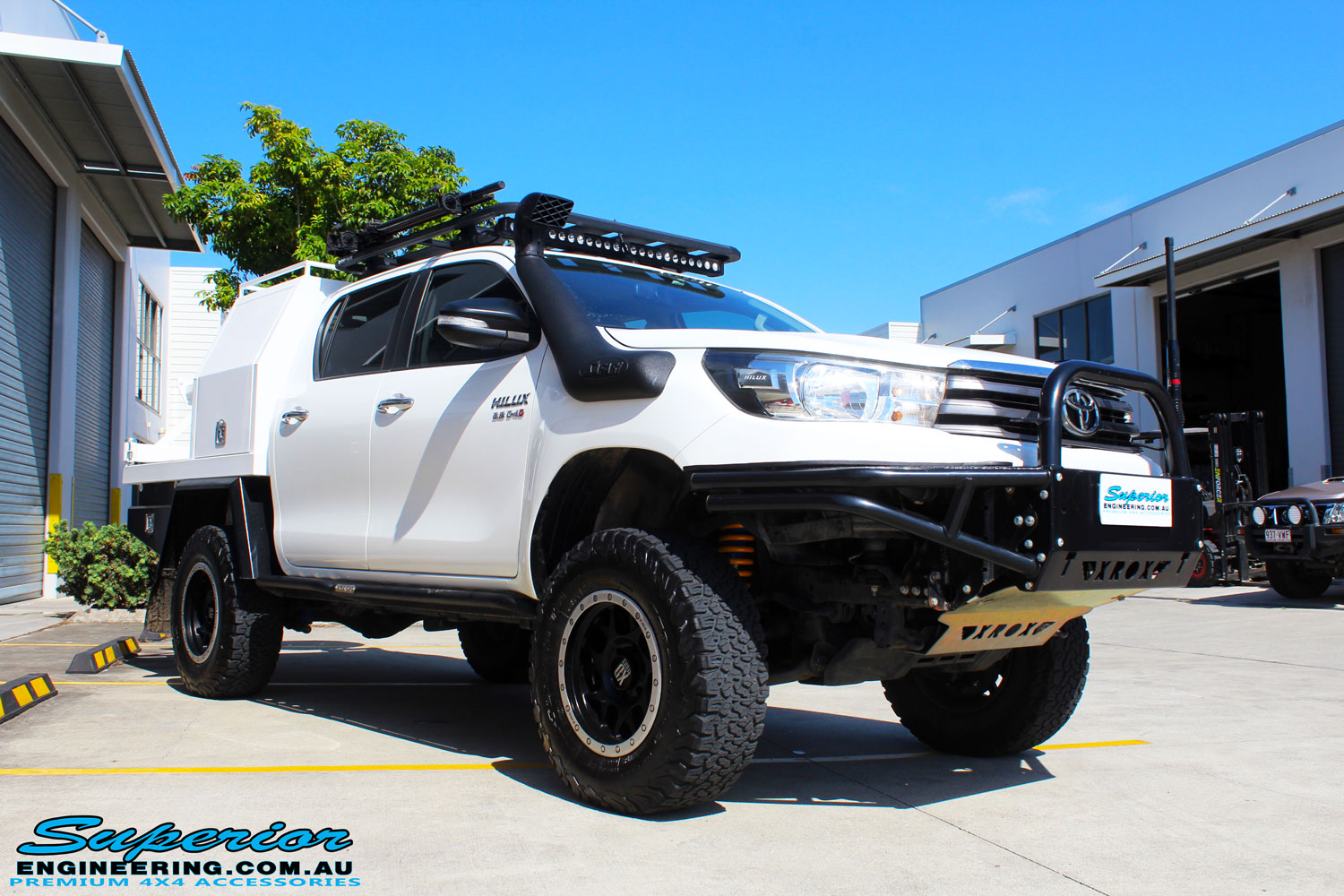 Right front side view of a White Toyota Revo Hilux Dual Cab after fitment of Adjustable Remote Reservoir Front Struts & King Coil Springs