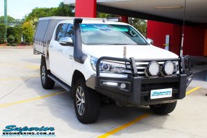 Right front side view of a White Toyota Revo Hilux Dual Cab being fitted with a Brown Davis 145L Long Range Fuel Tank @ Superior