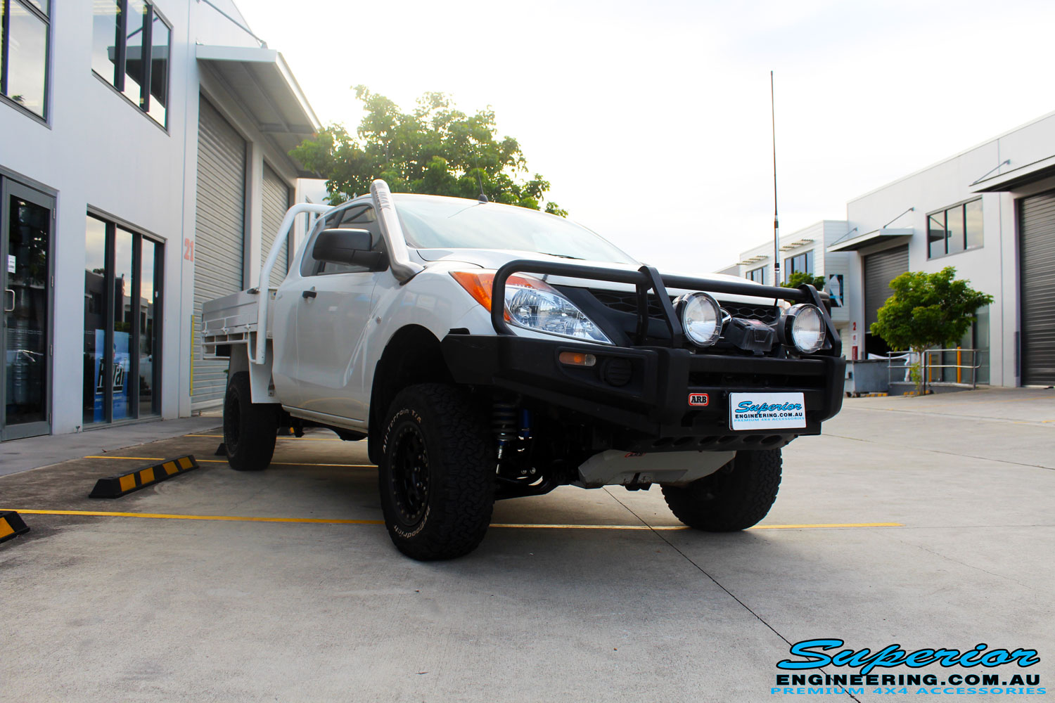 Right front side view of a Mazda BT50 in White after fitment of a Superior 3" Inch Remote Reservoir Lift Kit with Nitto Terra Grappler Tyres + ROH Black Steel Wheels